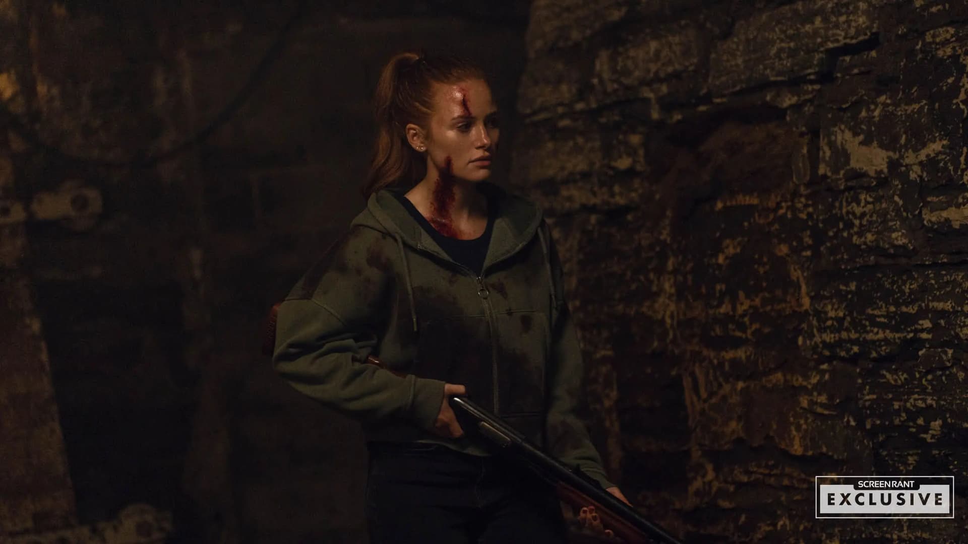 Madelaine Petsch as Maya in The Strangers – Chapter 3, bloodied and holding a shotgun during a tense finale moment