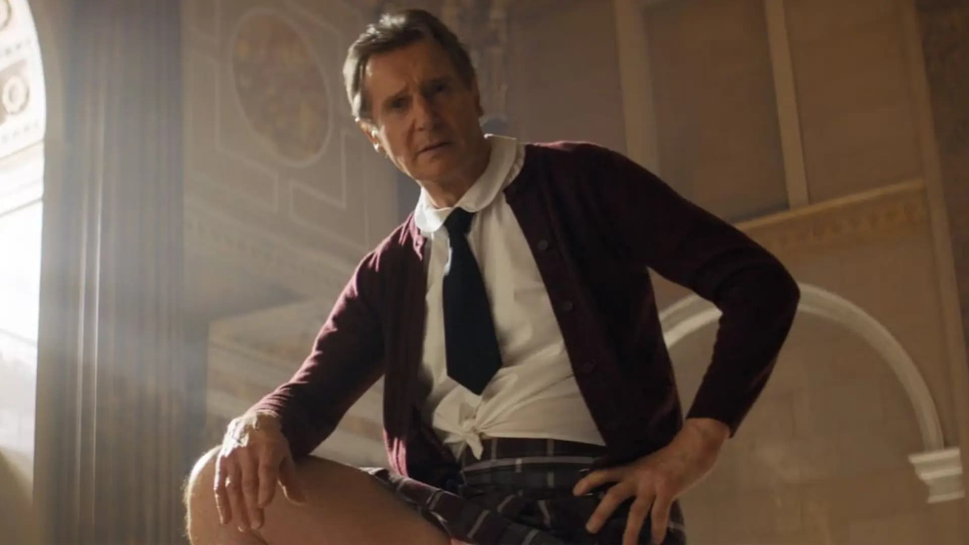 Liam Neeson as Frank Drebin Jr. aiming his gun in the 2025 The Naked Gun reboot